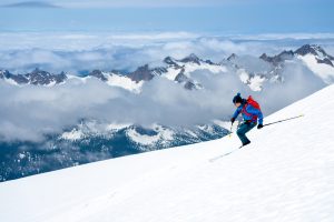Man skis down a steep snowy slope