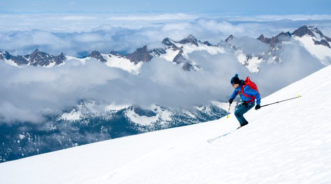 Man skis down a steep snowy slope